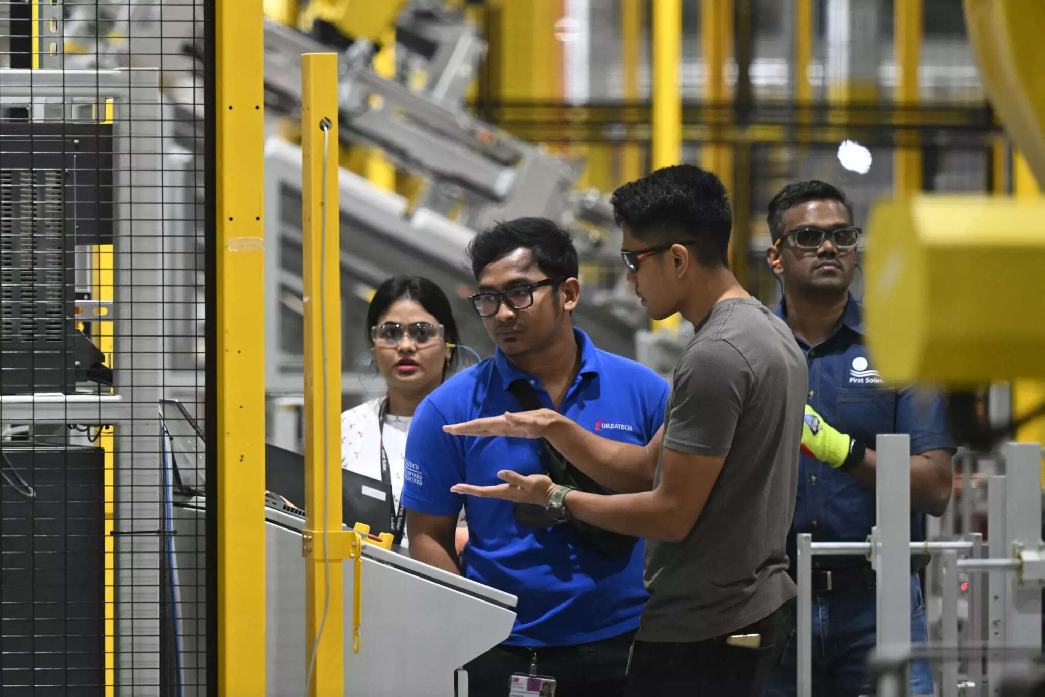 Technical team reviewing equipment on a manufacturing floor